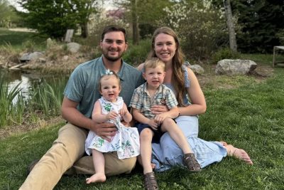 Kassey Davidson with her family sitting on a grassy garden.