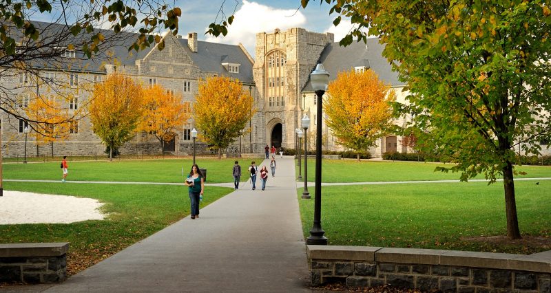 Students walking on the Drillfield in front of a residence hall